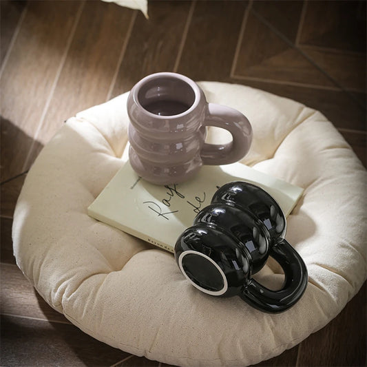 BLACK AND PURPLE COLOUR DONUT MUG ON A CHAIR FOR DISPLAY